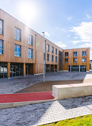 Universität Witten-Herdecke Fotos eines großen Holzgebäudes mit Holzfassade und Flachdach