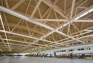 Montagehalle Pilatus CH-Stans Foto der Montagehalle Pilatus CH-Stans. Zu sehen ist eine große Brettschichtholz-Dachkonstruktion.